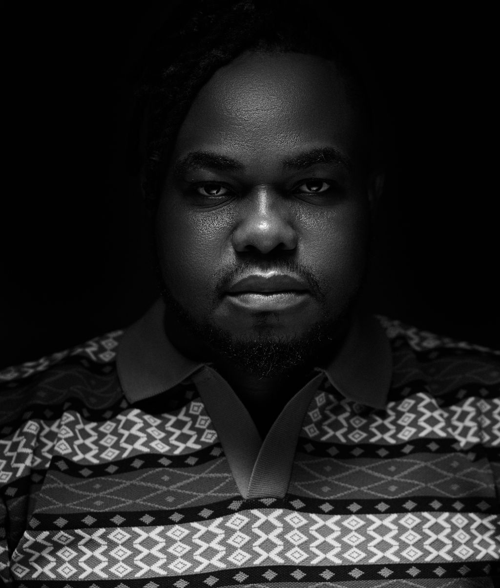 Black-and-white portrait of Tai Ajayi looking directly at the camera